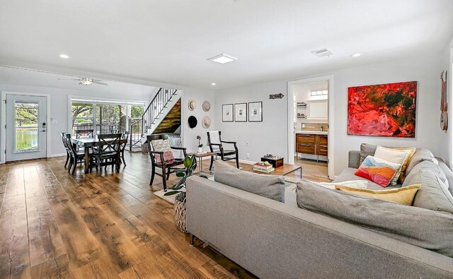living room with visible vents, recessed lighting, ceiling fan, stairway, and wood-type flooring