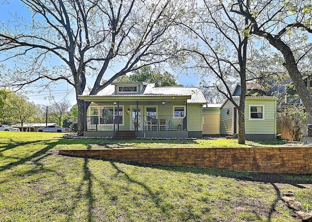 view of front of house with metal roof, a front lawn, and covered porch