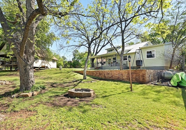 1318 Contour Dr, Burnet, TX 78611 - view of green lawn with a fire pit and covered porch