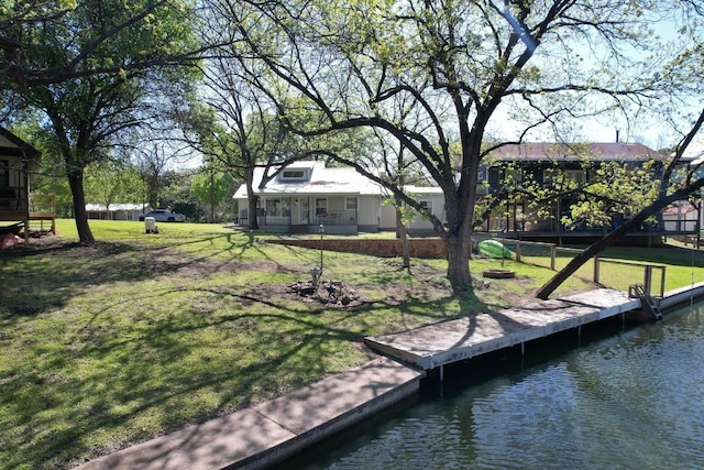 dock area with a lawn and a water view