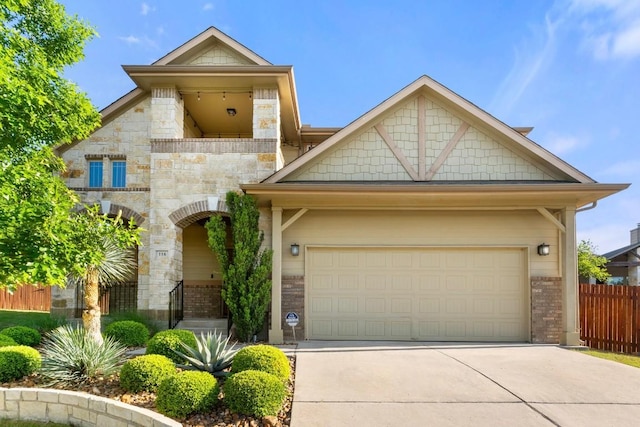 view of front facade with stone siding, brick siding, concrete driveway, an attached garage, and fence