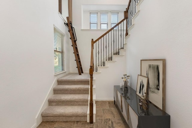 116 Silkstone St, Hutto, TX 78634 - staircase featuring healthy amount of natural light, baseboards, a high ceiling, and stone finish flooring