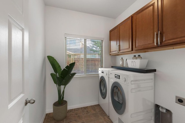 clothes washing area with baseboards, cabinet space, and independent washer and dryer