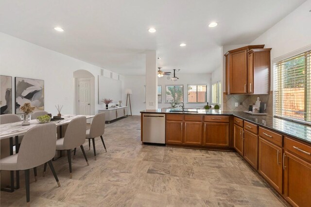kitchen with a sink, dishwasher, brown cabinets, and a healthy amount of sunlight