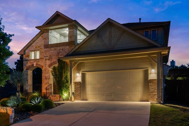 view of front of home featuring stone siding and concrete driveway