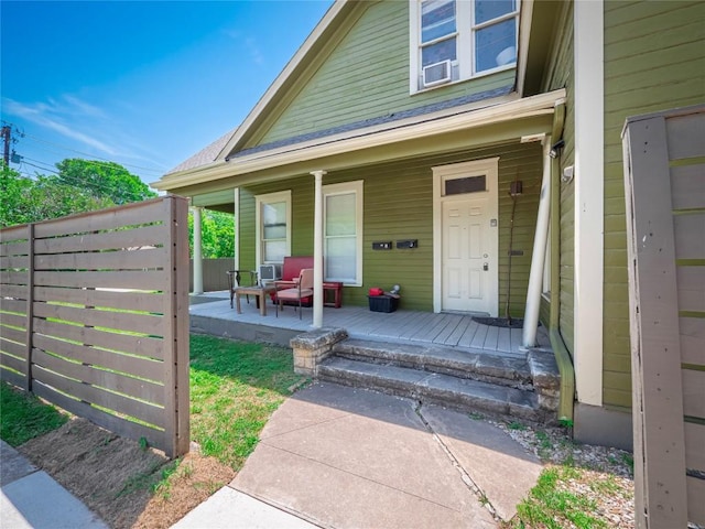 property entrance featuring a porch and fence