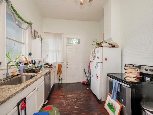 kitchen featuring a sink, stainless steel appliances, white cabinetry, dark wood-style flooring, and light stone countertops