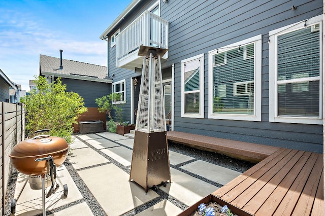 view of patio / terrace with a balcony, grilling area, and fence