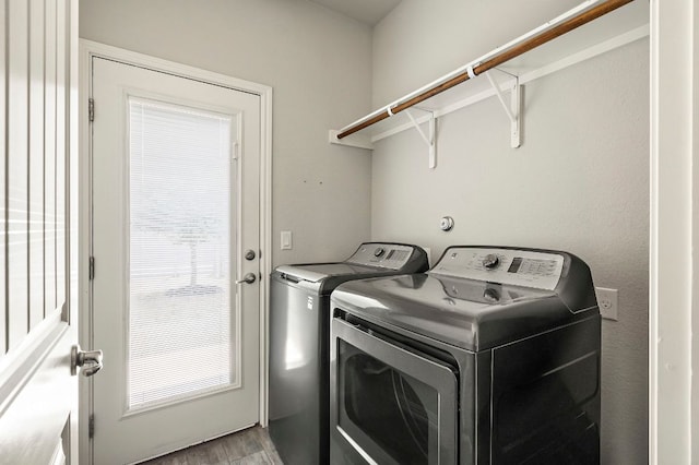 laundry room featuring washing machine and dryer, laundry area, and light wood-type flooring