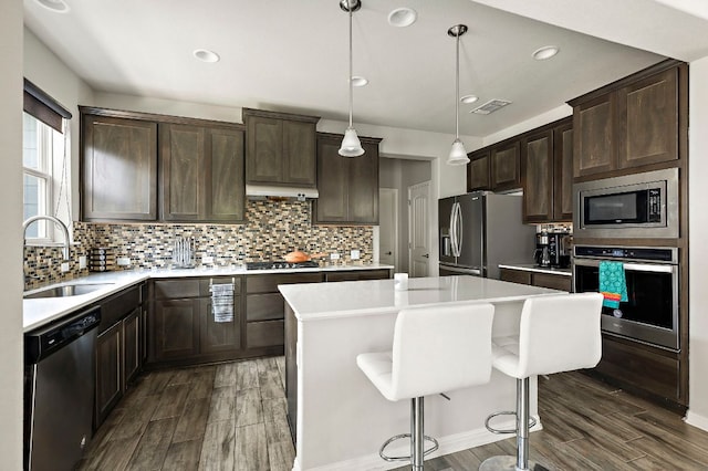kitchen featuring a sink, visible vents, stainless steel appliances, dark brown cabinetry, and dark wood-type flooring