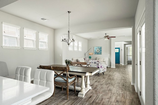 dining room featuring dark wood finished floors, visible vents, and a healthy amount of sunlight