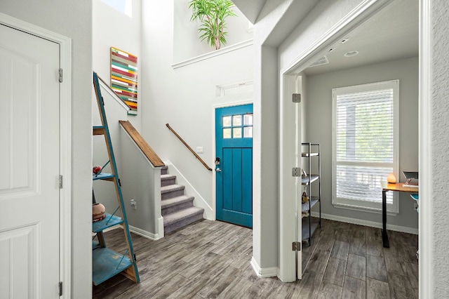 entryway featuring a wealth of natural light, wood finished floors, stairs, and baseboards