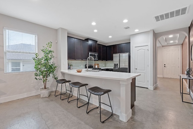 6224 Aviara Dr Unit E14, Austin, TX 78735 - kitchen featuring appliances with stainless steel finishes, finished concrete flooring, a breakfast bar area, a peninsula, and baseboards
