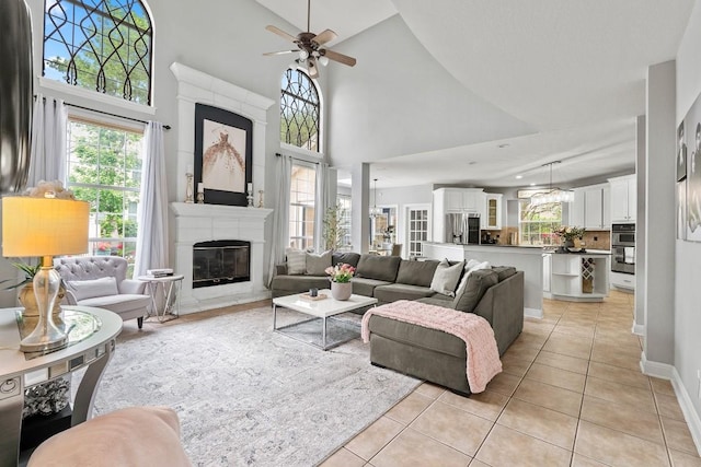 2128 Hilton Head Dr, Round Rock, TX 78664 - living area with light tile patterned floors, a ceiling fan, a high end fireplace, and high vaulted ceiling