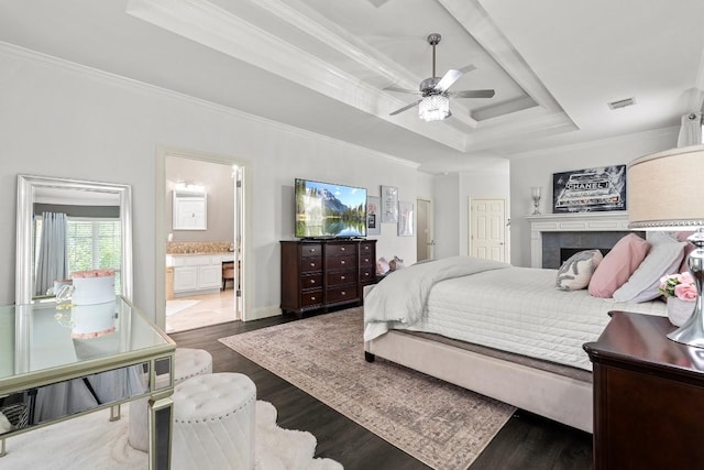 2128 Hilton Head Dr, Round Rock, TX 78664 - bedroom featuring a raised ceiling, wood finished floors, ornamental molding, ensuite bath, and a tiled fireplace