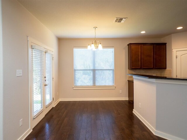 unfurnished dining area with a chandelier, dark wood finished floors, baseboards, visible vents, and recessed lighting