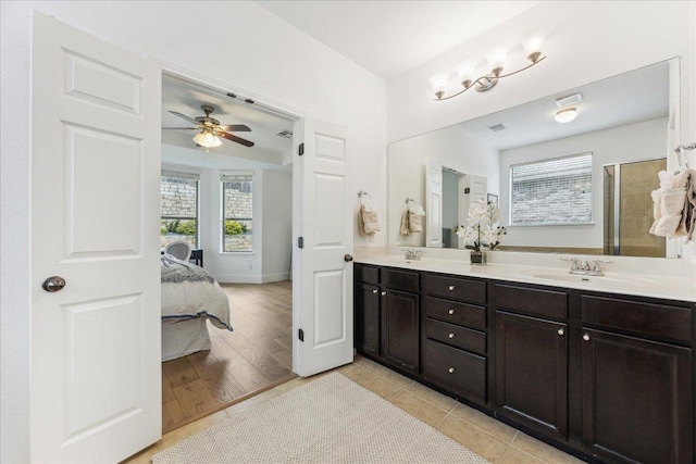 ensuite bathroom with ceiling fan, double vanity, a shower with door, and wood finished floors