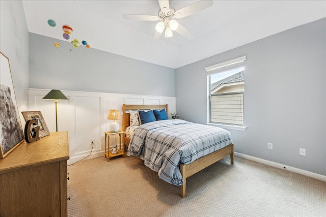 bedroom with light colored carpet, a ceiling fan, and a wainscoted wall