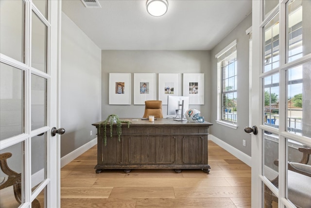 office with french doors, light wood-type flooring, and baseboards