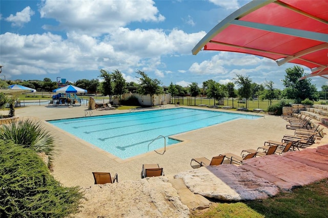 community pool featuring fence and a patio area