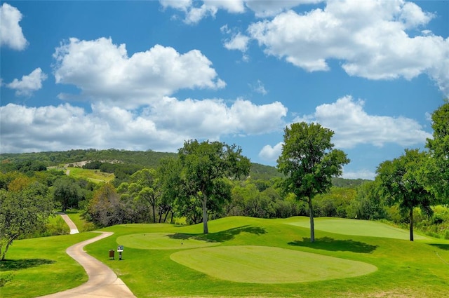 surrounding community featuring golf course view and a yard