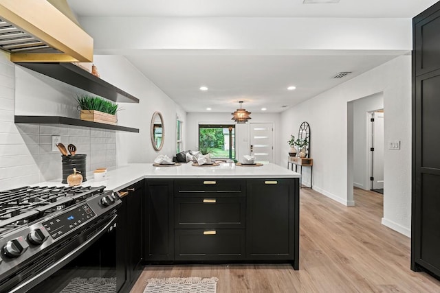 5602 Joe Sayers Ave, Austin, TX 78756 - kitchen with stainless steel range with gas cooktop, open shelves, a peninsula, light countertops, and recessed lighting