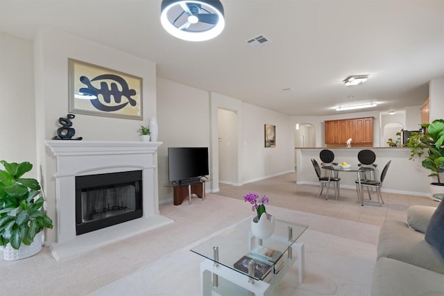 living room with a fireplace with raised hearth and visible vents