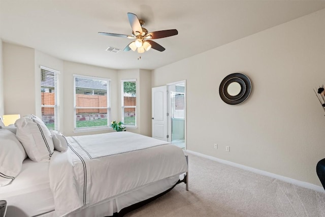bedroom with visible vents, a ceiling fan, baseboards, light colored carpet, and ensuite bathroom