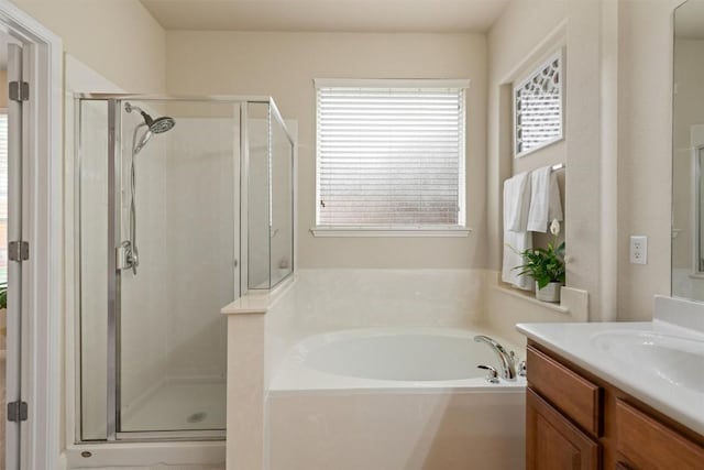 bathroom featuring a shower stall, a garden tub, and vanity