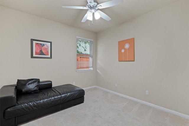 living area with a ceiling fan, baseboards, and light carpet