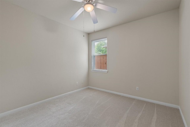 unfurnished room with baseboards, a ceiling fan, and light colored carpet
