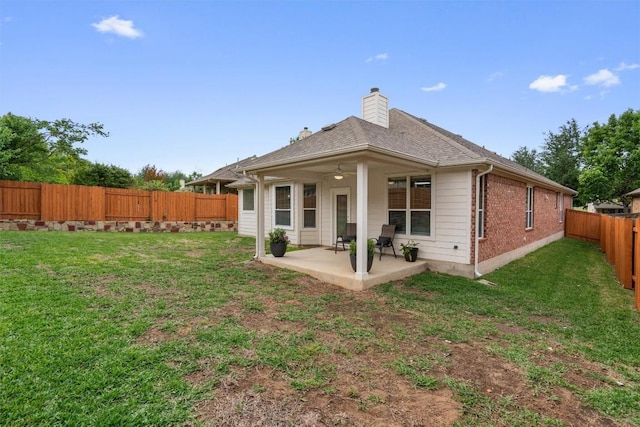 rear view of house with a yard, a fenced backyard, a patio, and a chimney