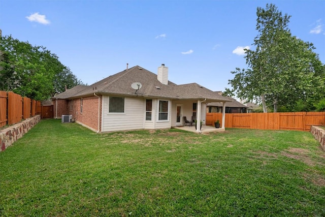 back of house with a chimney, a fenced backyard, central air condition unit, a patio area, and a lawn