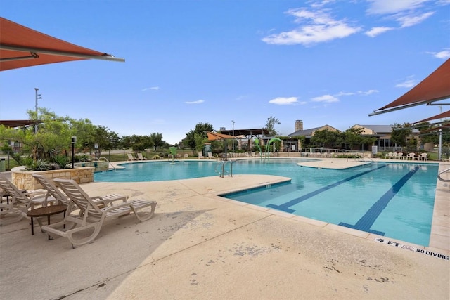 community pool featuring a patio and fence