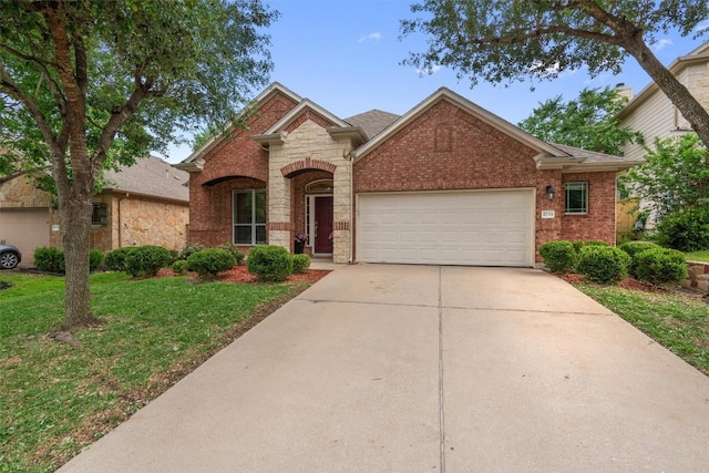 view of front of property with driveway, stone siding, an attached garage, a front yard, and brick siding