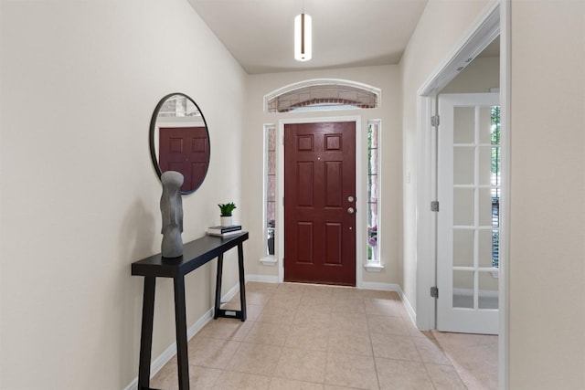 entryway featuring baseboards and light tile patterned flooring
