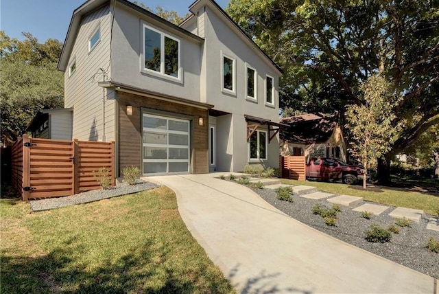 modern home featuring a garage, stucco siding, driveway, and a front yard
