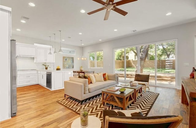 living area with light wood-style floors, a ceiling fan, recessed lighting, and visible vents
