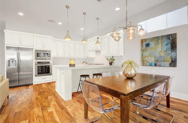 kitchen with built in appliances, white cabinetry, visible vents, and light countertops