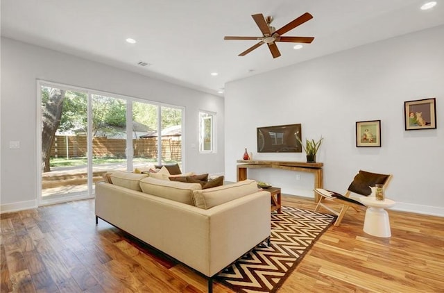 living room with a ceiling fan, recessed lighting, wood finished floors, and visible vents