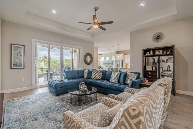513 Freeing Oak St, San Marcos, TX 78666 - living room with light wood-type flooring, a ceiling fan, a raised ceiling, baseboards, and recessed lighting