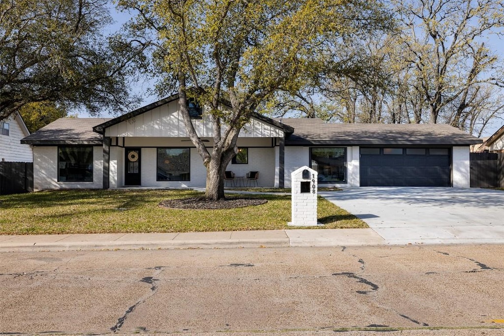 1908 Carter Creek Pkwy, Bryan, TX 77802 - view of front of property featuring concrete driveway, a front lawn, fence, and a garage