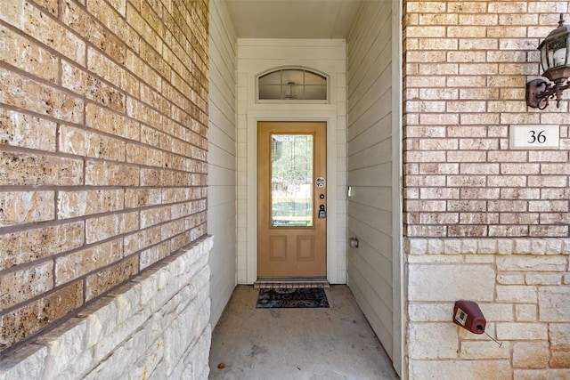 entrance to property featuring brick siding