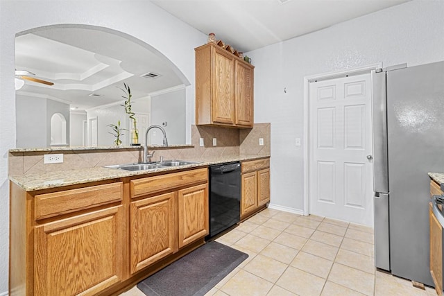 kitchen featuring arched walkways, tasteful backsplash, dishwasher, and a sink