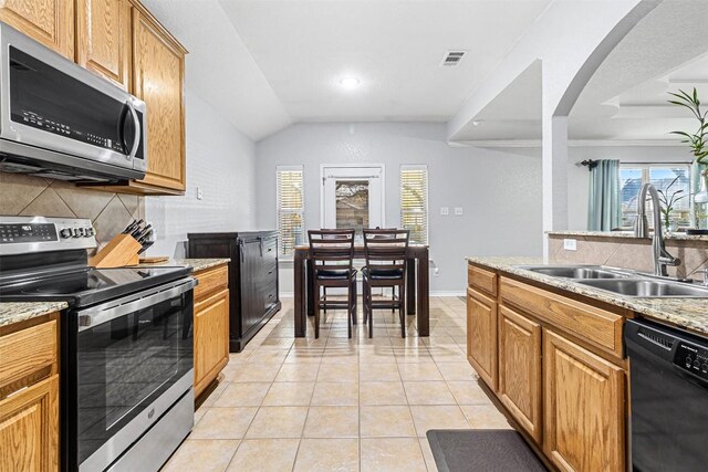kitchen with a sink, decorative backsplash, a wealth of natural light, stainless steel appliances, and visible vents