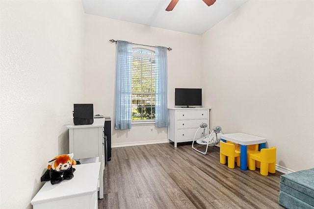 recreation room featuring baseboards, wood finished floors, ceiling fan, and a healthy amount of sunlight