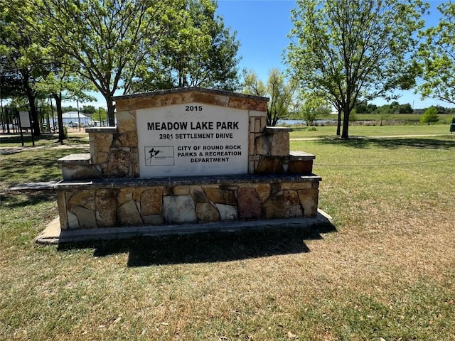 community / neighborhood sign with a yard
