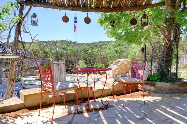 view of patio / terrace featuring fence and a forest view