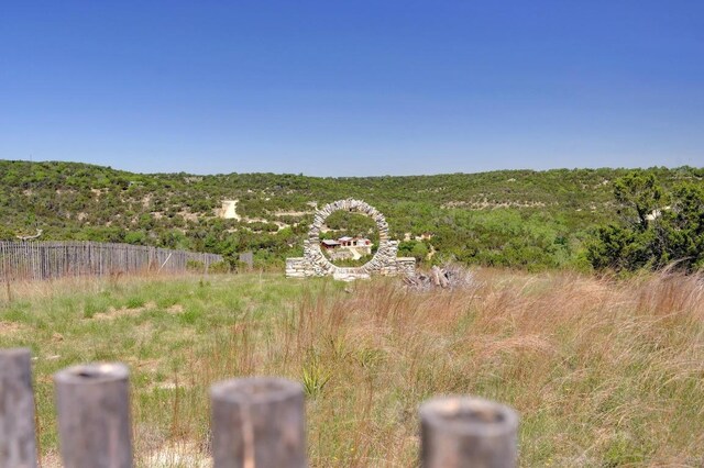 view of yard featuring a forest view and fence