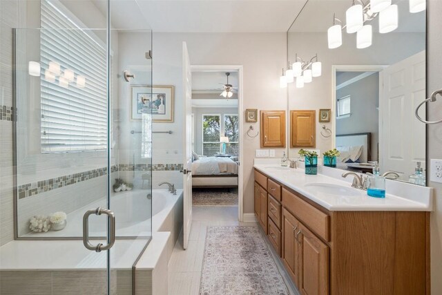 ensuite bathroom featuring a bathtub, connected bathroom, a stall shower, and a sink